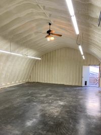 Spray foam lining the inside of a Quonset Hut